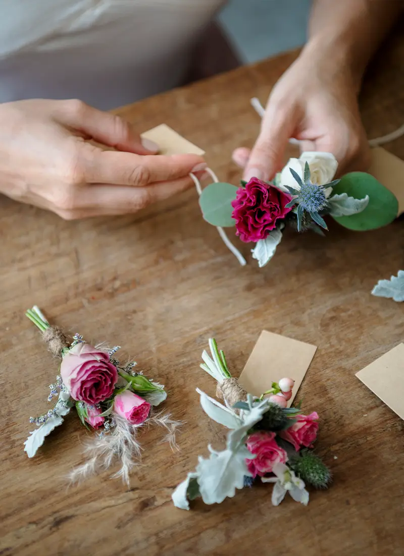 Fleuriste composant une boutonnière de mariage