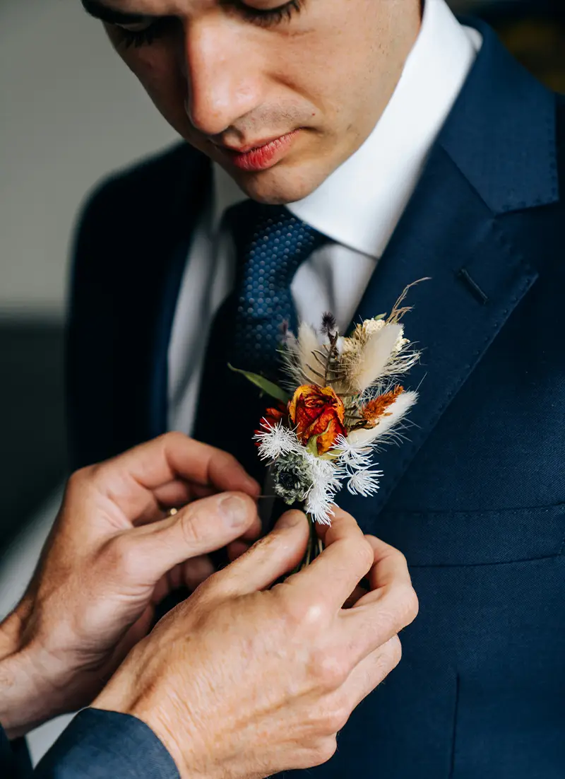Marié attachant sa boutonnière en fleur